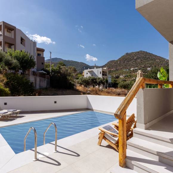 Private outdoor pool area of a maisonette suite with sun loungers and mountain views