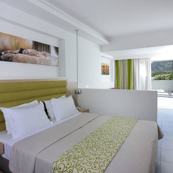 bright modern room with a double bed, wall art, and balcony access with a view