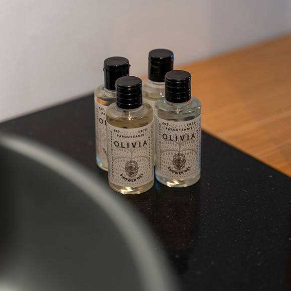 Close-up of four toiletry bottles on a black bathroom sink