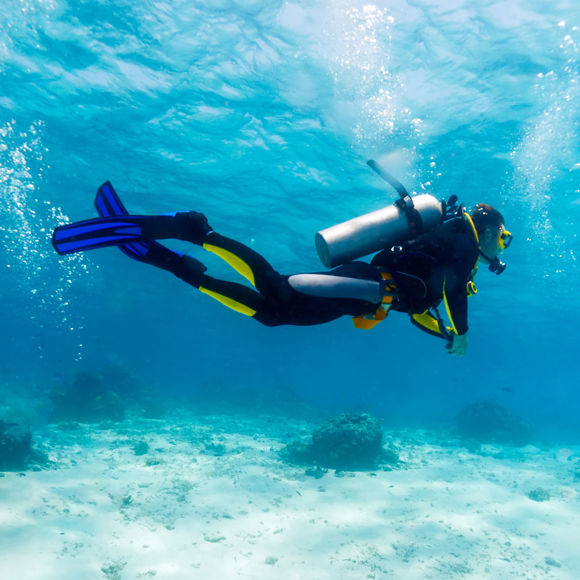 Scuba diver exploring the waters, surrounded be clear blue sea