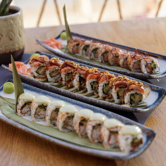 Plates of assorted sushi rolls with wasabi and pickled ginger, served at Mambo Beach Restaurant