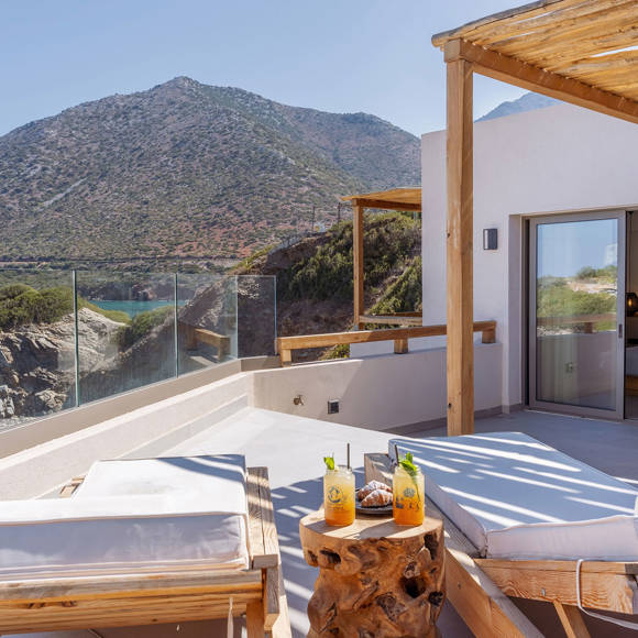 Junior suite private pool area with a pair of sun loungers and a direct sea and mountain view