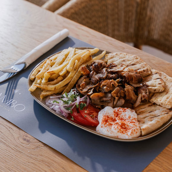 Traditional pork gyros plate with fries, pita bread, tzatziki, tomato and onion, served at Mambo Beach Restaurant