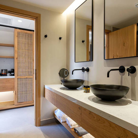 Junior Suite bathroom with double black vessel sinks, wooden vanity and large mirrors