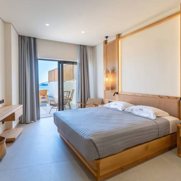 Junior suite, featuring a double bed, wall-mounted TV, pendant lights and access to a furnished outdoor area with a private pool