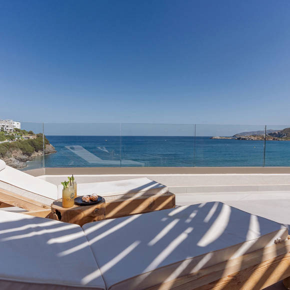 Junior suite private pool area with a pair of sun loungers and a direct sea and mountain view