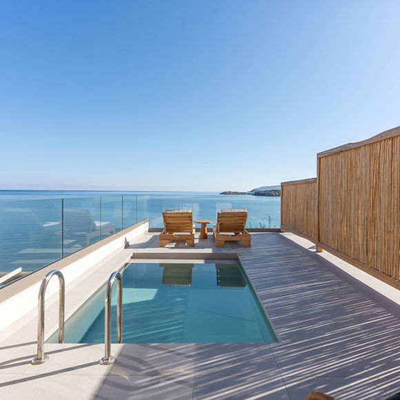 Suite's terrace area with private pool, shady sitting area, sun loungers and sea view