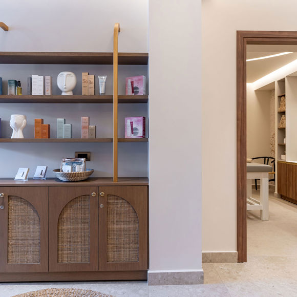 Display shelves with skincare and wellness products next to the entrance of the treatment area