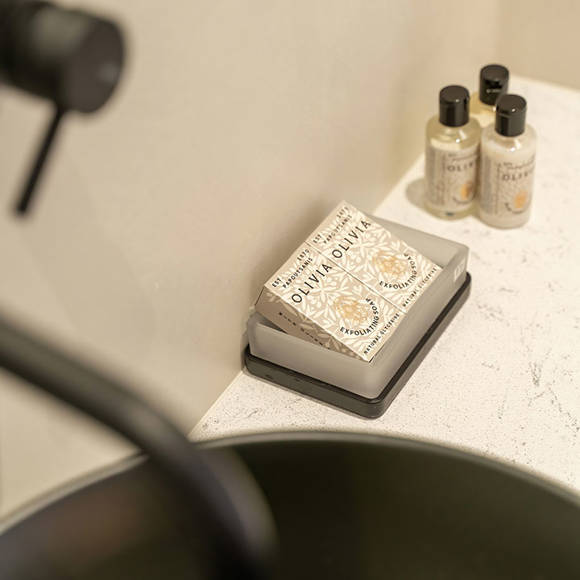 Close-up of a black sink in a junior suite sea front bathroom with toiletries and soap on the counter