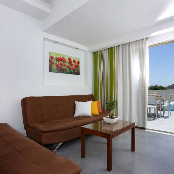 living area with two brown sofas, a coffee table, and access to a terrace with a view