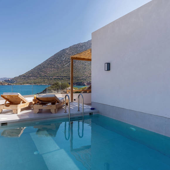 Junior suite private pool area with a pair of sun loungers and a direct sea and mountain view