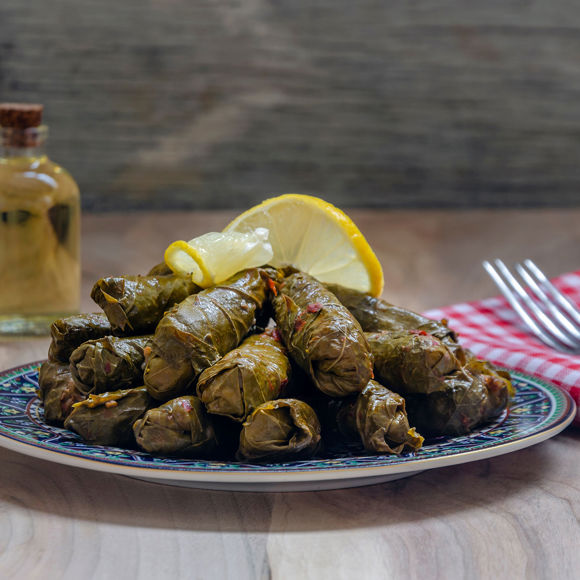 Plate of traditional stuffed vine leaves (dolmadakia) garnished with lemon