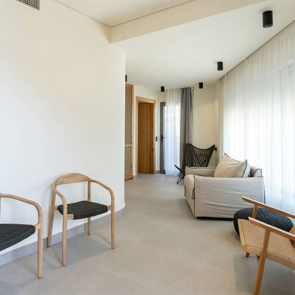 Suite's cozy living room with modern furniture, and a wall-mounted TV 