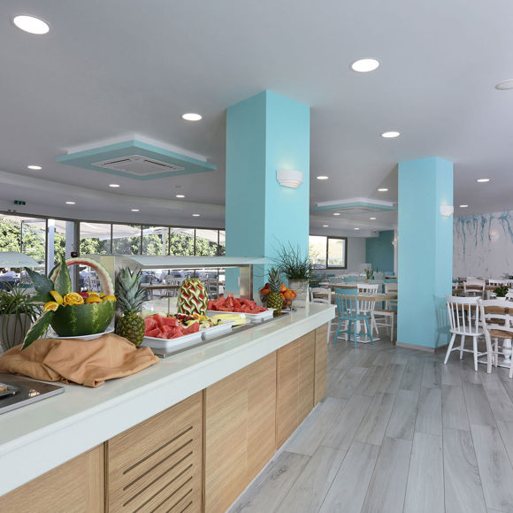 Main restaurant with bright interior and buffet area featuring fresh fruit and pastries