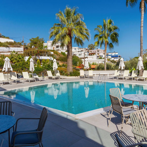 View from the shaded outdoor dining area next to the pool showing the poolside setting