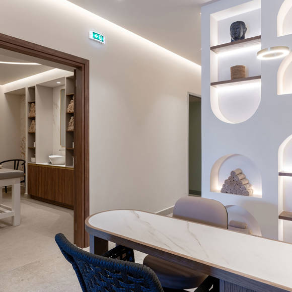 Interior of the spa reception area, featuring build-in display niches, ambient lighting and modern design aesthetic