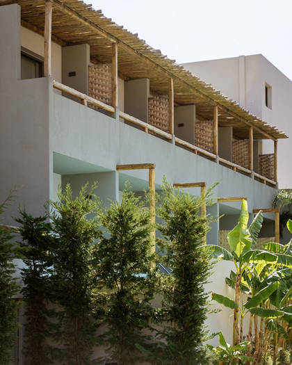 Exterior view of a Bali Star Hotel building with private balconies, wooden pergolas and lush garden greenery